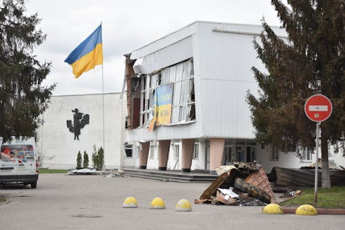 Ukraine Flag Next to Damaged Building 