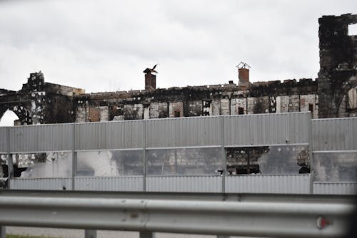 Burnt Building behind Noise Barrier