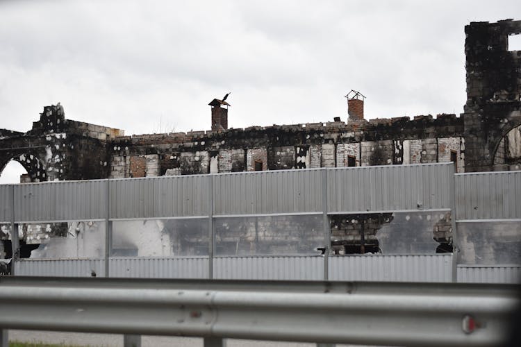 Burnt Building Behind Noise Barrier