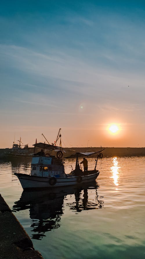 Silhouette of Boat on Sea During Sunset