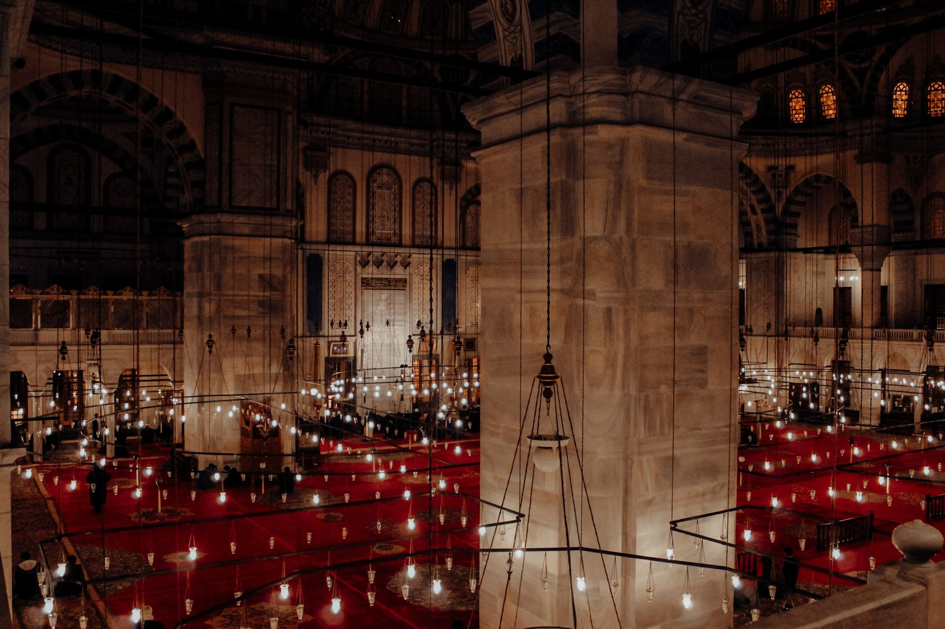 A serene view of the Fatih Mosque interior showcasing intricate lighting and architectural elegance.