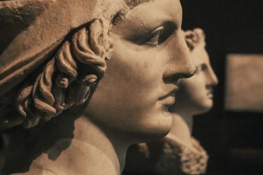 Fine art detail of ancient marble sculptures in a museum setting.
