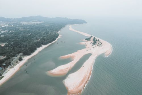 Free A breathtaking aerial view of a peaceful and lush coastline with foggy ambiance. Stock Photo