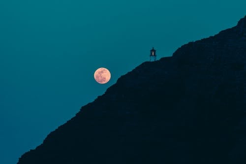 Free Silhouette of Person Standing on Rock Formation during Night Time Stock Photo