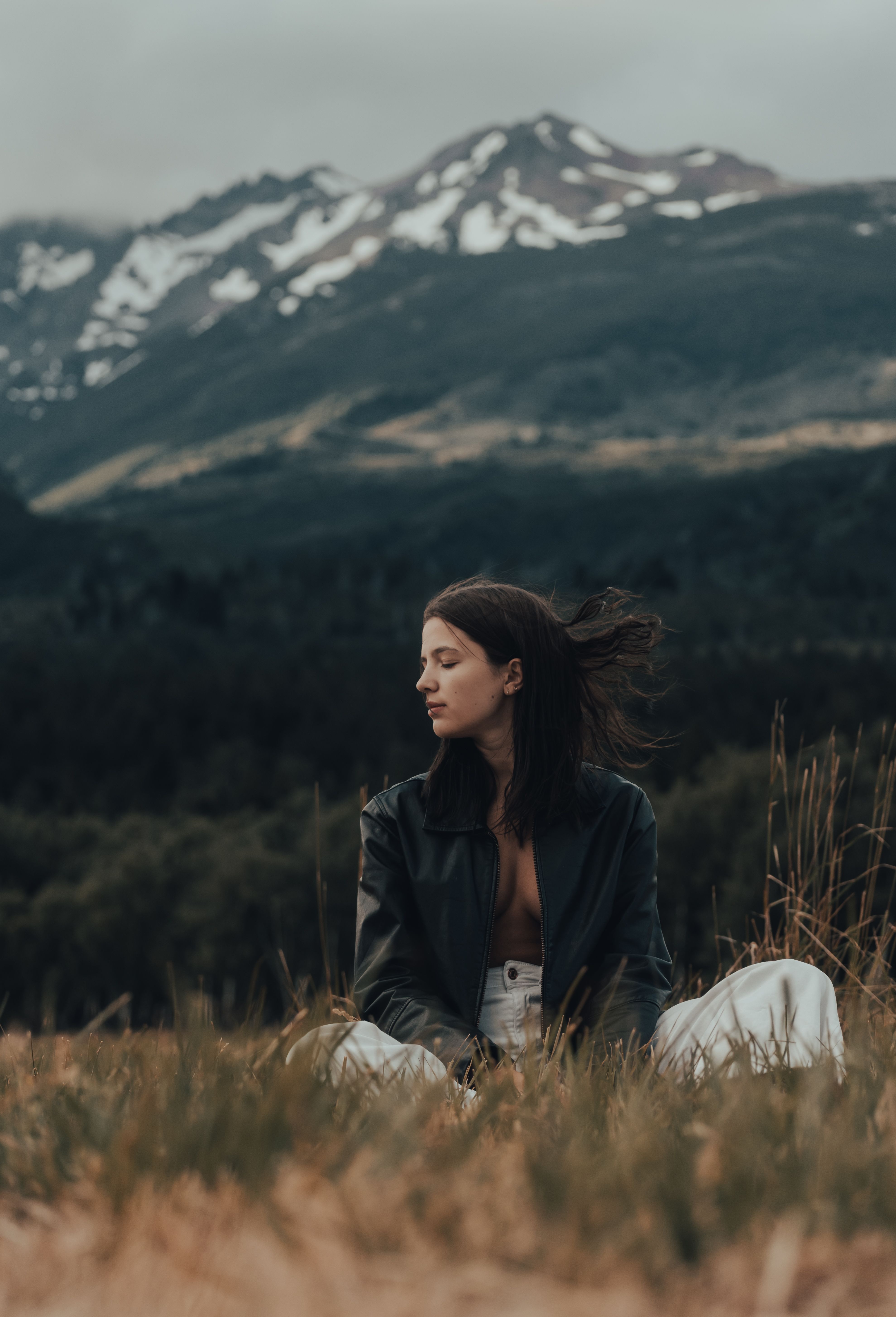 Woman Sitting on a Field in Mountains · Free Stock Photo