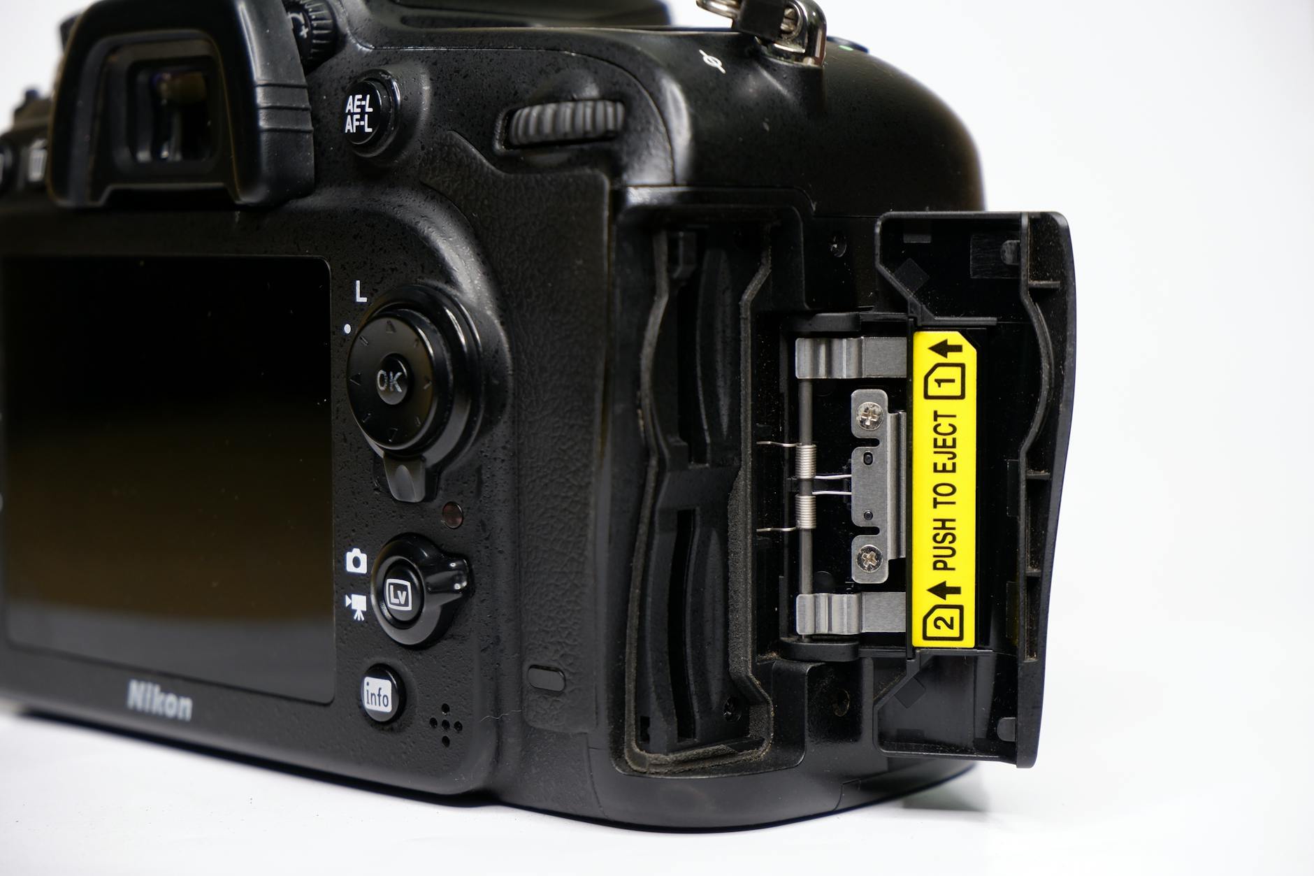 Detailed image of a camera's back showcasing open memory card slot, emphasizing professional equipment.