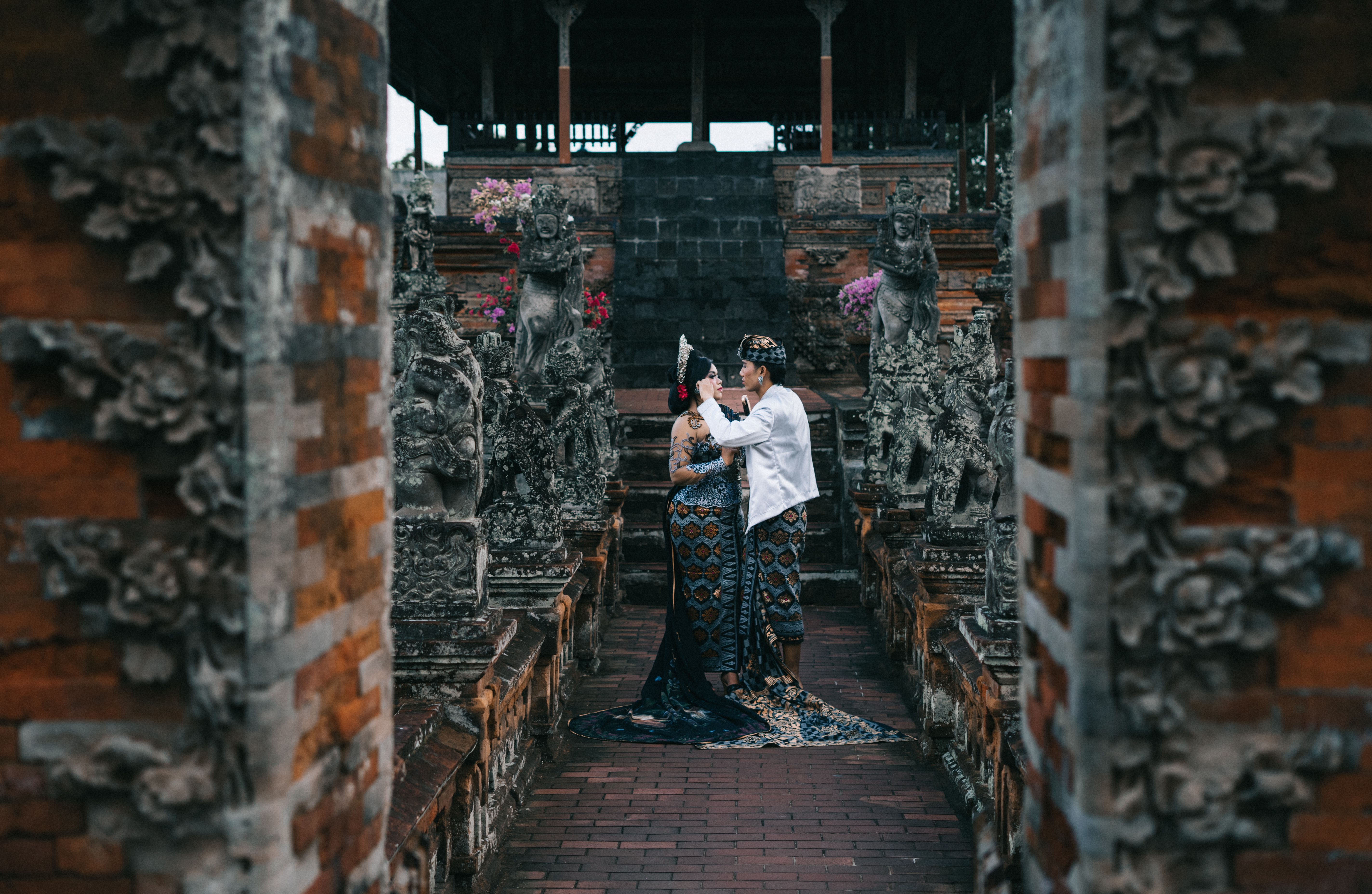 Traditional Balinese temple courtyard after a cockfight ritual, incense smoke and quiet observers