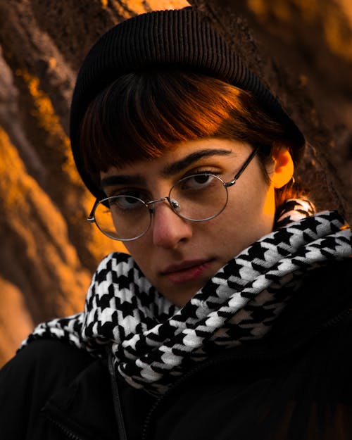 Hipster girl in glasses and black beanie with thumbs up Stock Photo