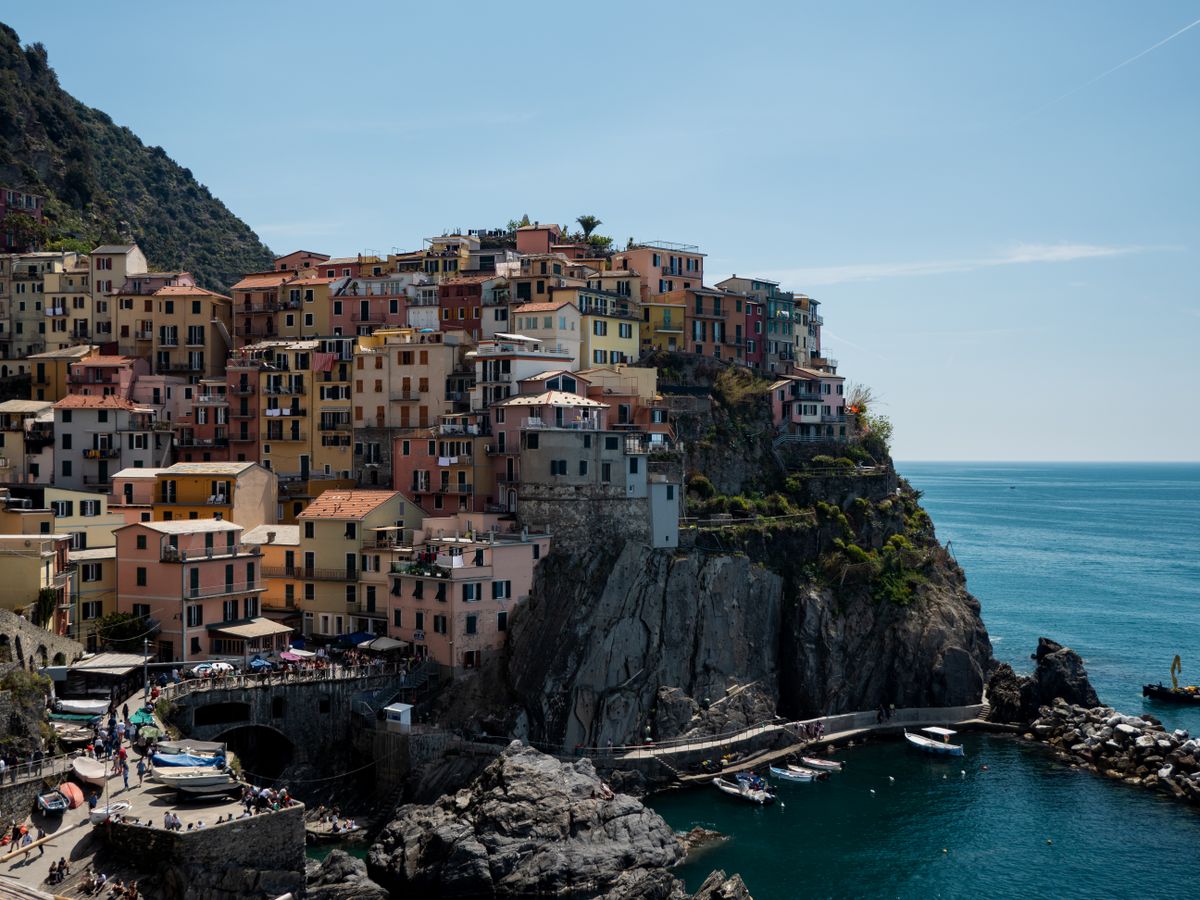 Manarola's tower of multicolored houses above the harbor — the Cinque Terre's most photographed village.