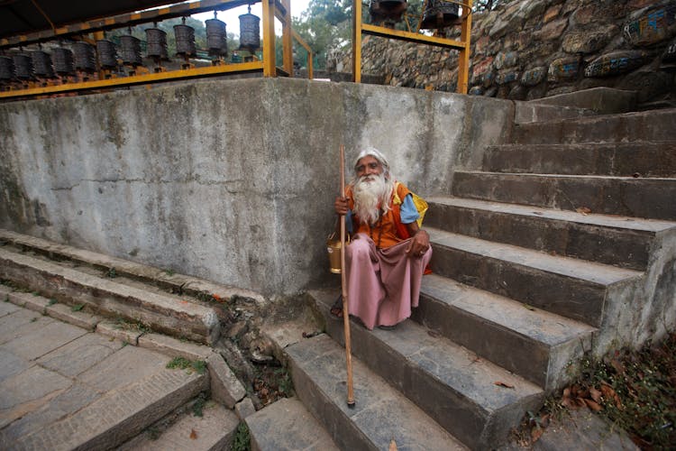 Man With Cane Sitting On Steps