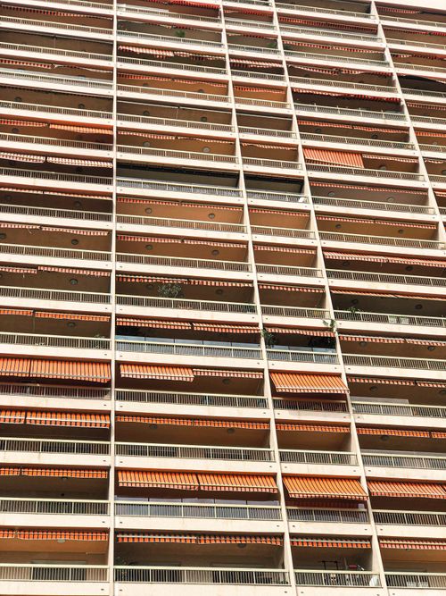 Free Low-angle view of a high-rise apartment building showcasing numerous balconies and awnings in Monaco. Stock Photo