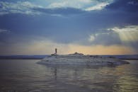 黄昏时分，一个孤独的身影站在荒凉的岛屿上，天空显得格外戏剧性