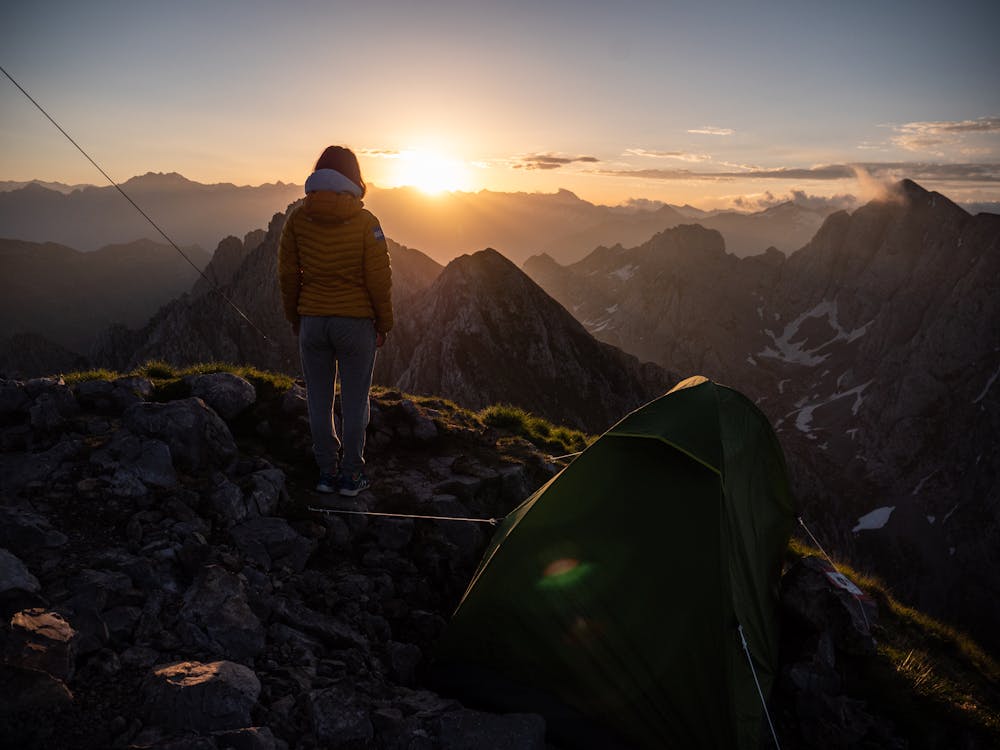 Free A Person Standing on the Mountain with Tent Stock Photo