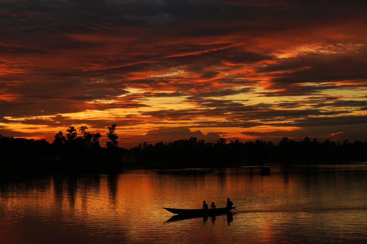 boat silhouettes against a vibrant sunset in sirajganj bangladesh
