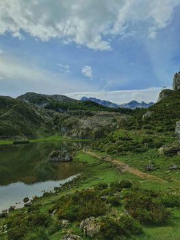 Scenic view of a tranquil lake surrounded by mountains in Asturias, ideal for nature enthusiasts.
