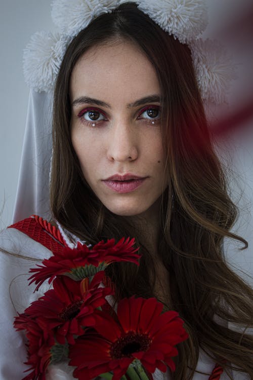 Portrait of Woman Holding Red Flowers