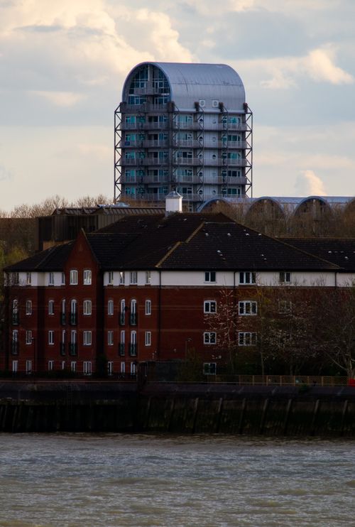 Free Contemporary apartment buildings by a riverfront with a clear sky. Stock Photo