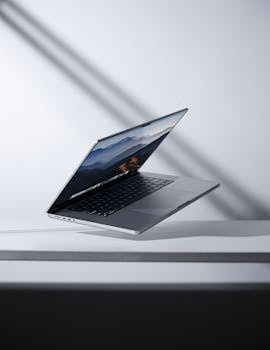 Modern laptop levitating in a minimalist studio setting. Perfect for technology themes.