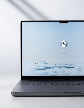 Sleek modern laptop displaying a serene cloud scene on the screen, indoors with natural light.