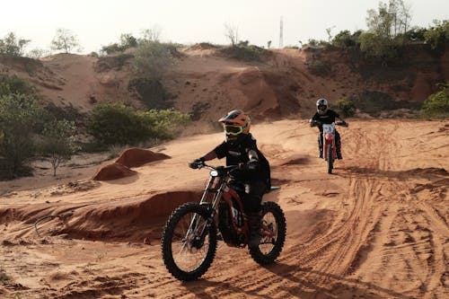Free Man in Black Helmet Riding Motocross Dirt Bike on Brown Rock Mountain Stock Photo