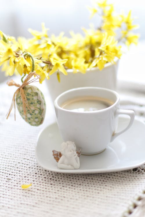 Free White Ceramic Cup on White Ceramic Saucer Beside Yellow Flowers Stock Photo