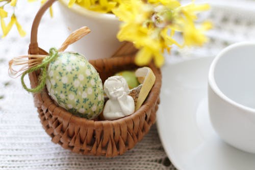 Close-up of a Basket with Easter Eggs and a Little Angle Figurine 