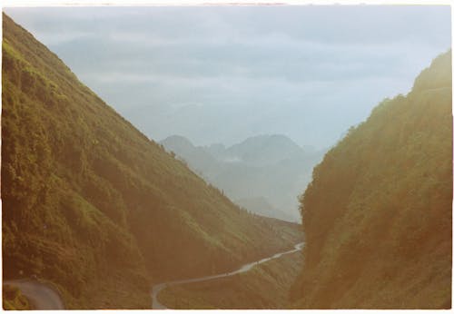 Road on Green Mountain Under White Sky