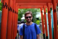 Man in Blue Crew Neck T-shirt Wearing Black Sunglasses at Torii at Hanazono Inari Jinja in Ueno Park, Tokyo, Japan