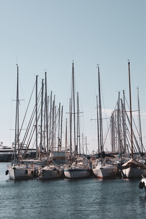 Free Calm harbor scene with sailboats moored at a marina on a sunny day. Stock Photo