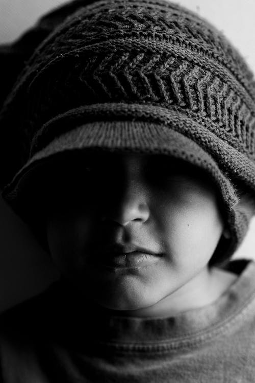 Grayscale Photo of a Boy Wearing Knitted cap