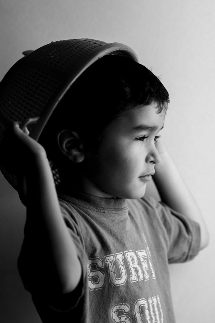 Grayscale Photo Of Boy Holding Round Plastic 