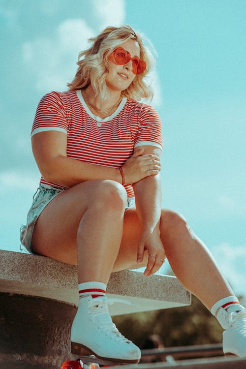 Woman Wearing Sunglasses and Roller Skates Sitting on Bench 