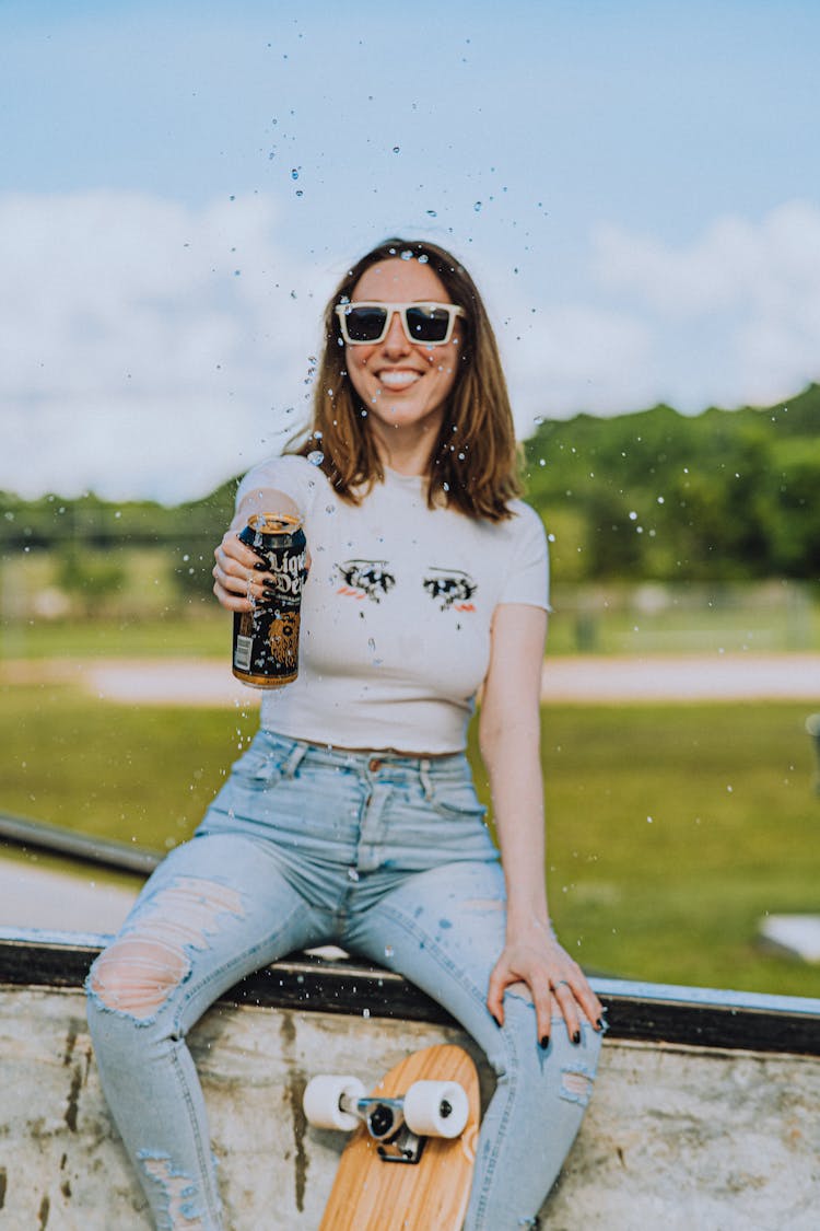 A Woman In White Crew Neck T-shirt Holding A Can Of Beer