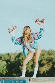 Woman posing dramatically with roller skates outdoors in retro outfit.