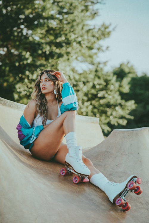 Beautiful Woman Sitting on a Skate Ramp Looking Sideways