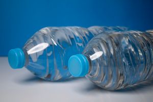 Clear plastic water bottles with blue caps — photo by nerea arance on Pexels