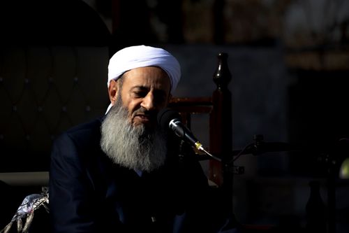 Free A religious leader speaks passionately during an outdoor Islamic ceremony. Stock Photo