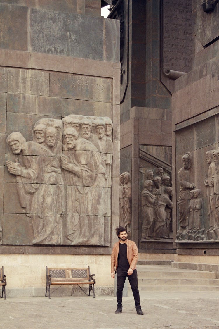 Man In Leather Jacket Standing Near Monument