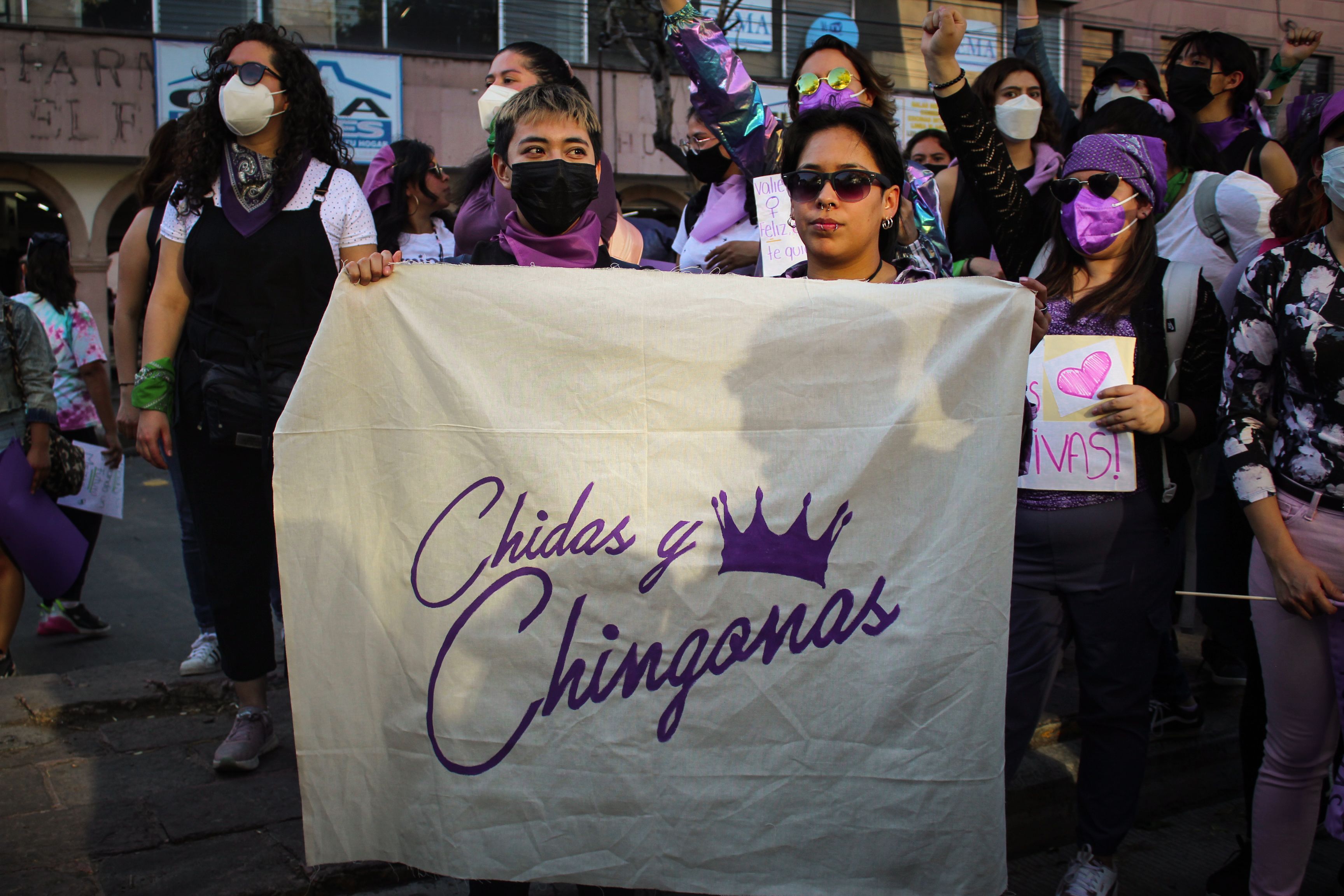 Group of women at a demonstration holding a banner promoting empowerment.