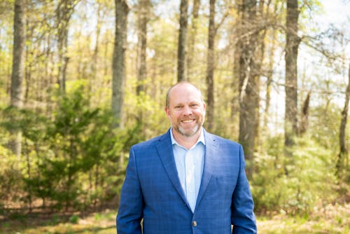 Man in Blue Suit Jacket Standing Near Trees