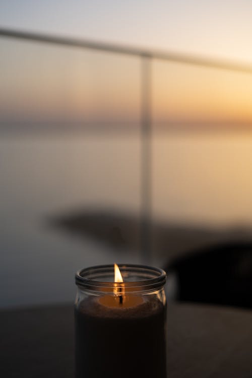Free Lighted Candle in Clear Glass on the Table Stock Photo