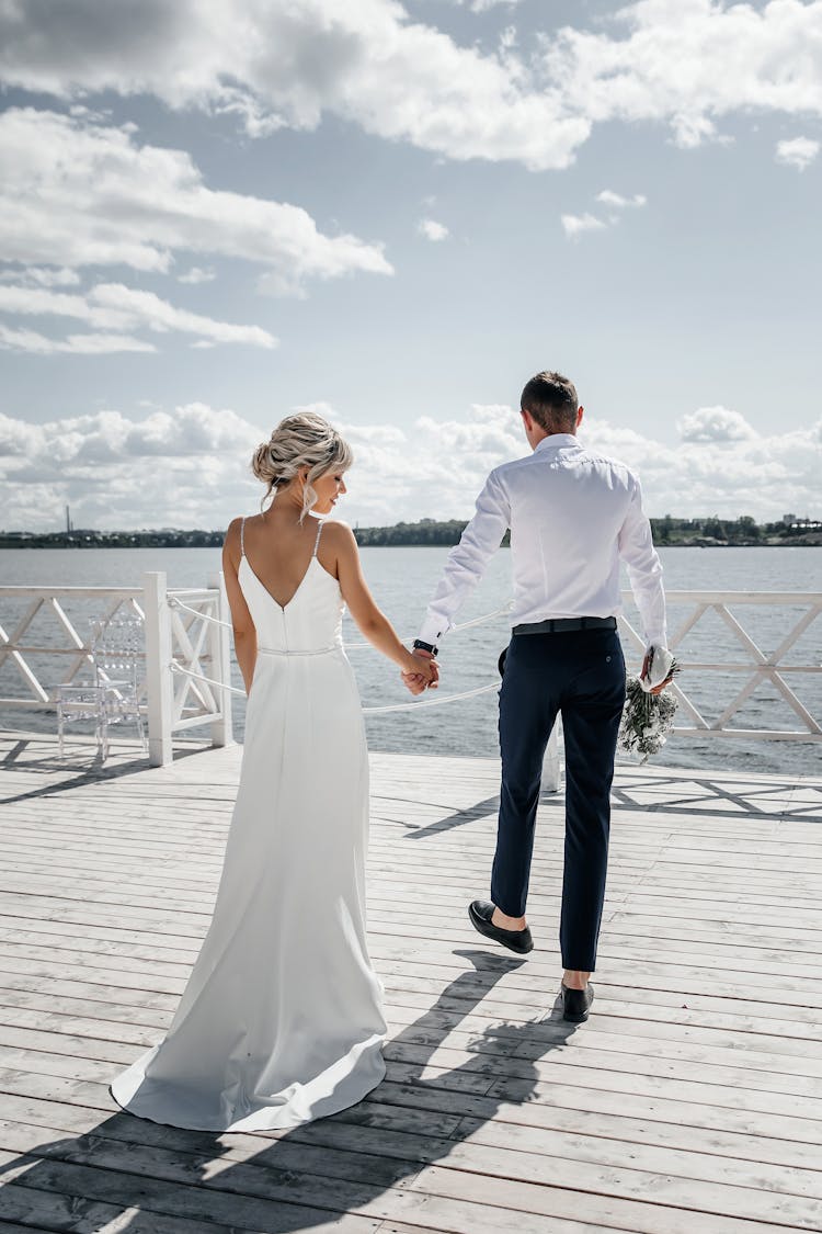 Back View Of A Romantic Wedding Couple On The Dock