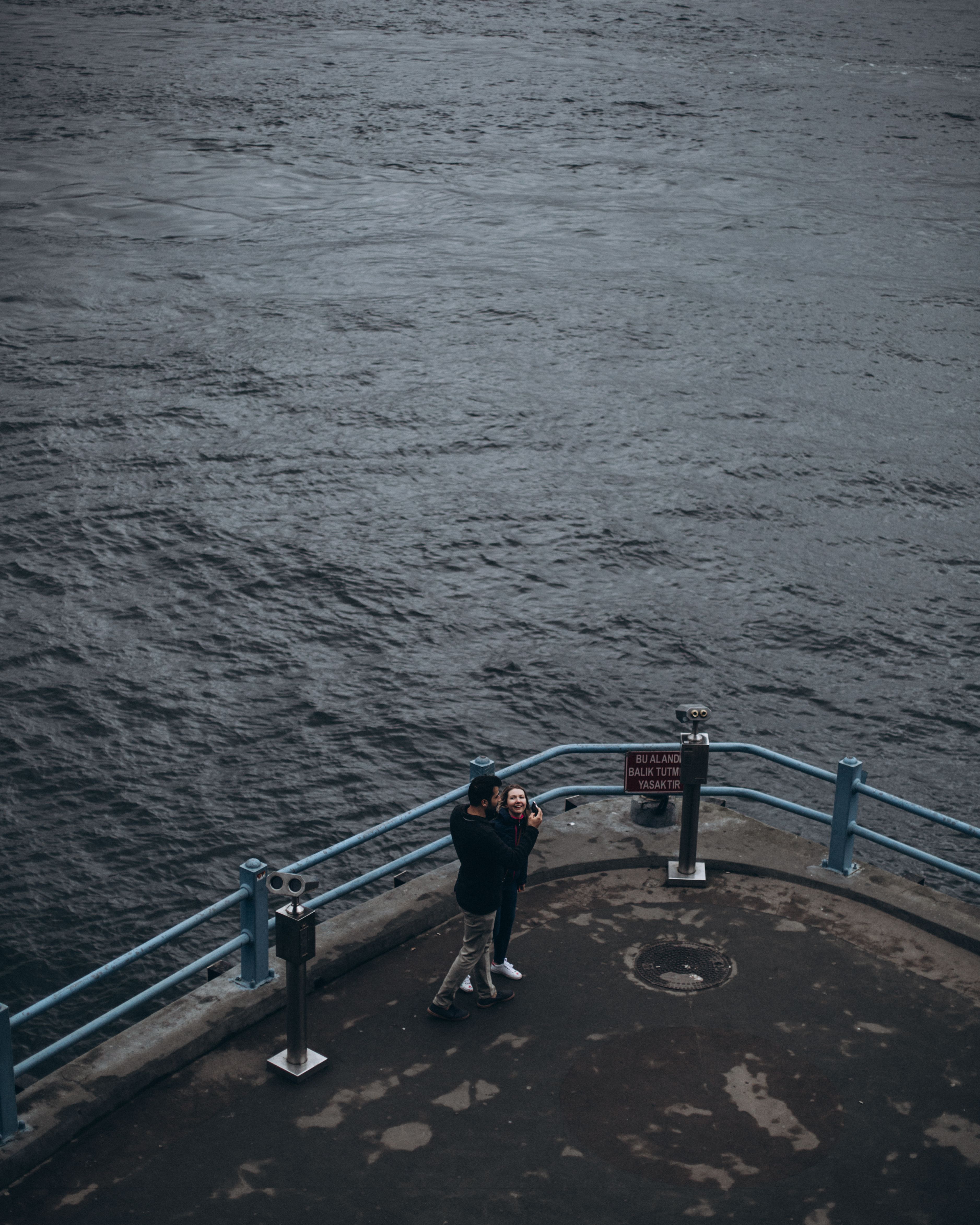 Aerial View of Man and Woman at the End of a Pier · Free Stock Photo