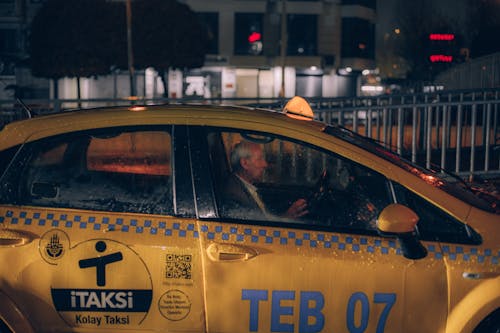 Man Driving a Yellow Taxi 