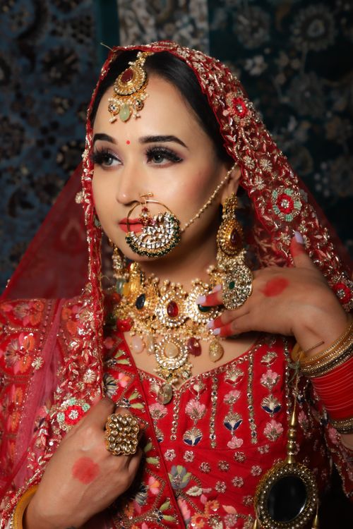 Free A stunning portrait of an Indian bride in vibrant red traditional attire, adorned with intricate jewelry. Stock Photo