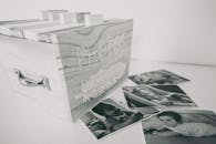Black and White Photo of Wooden Box with Photographs Scattered