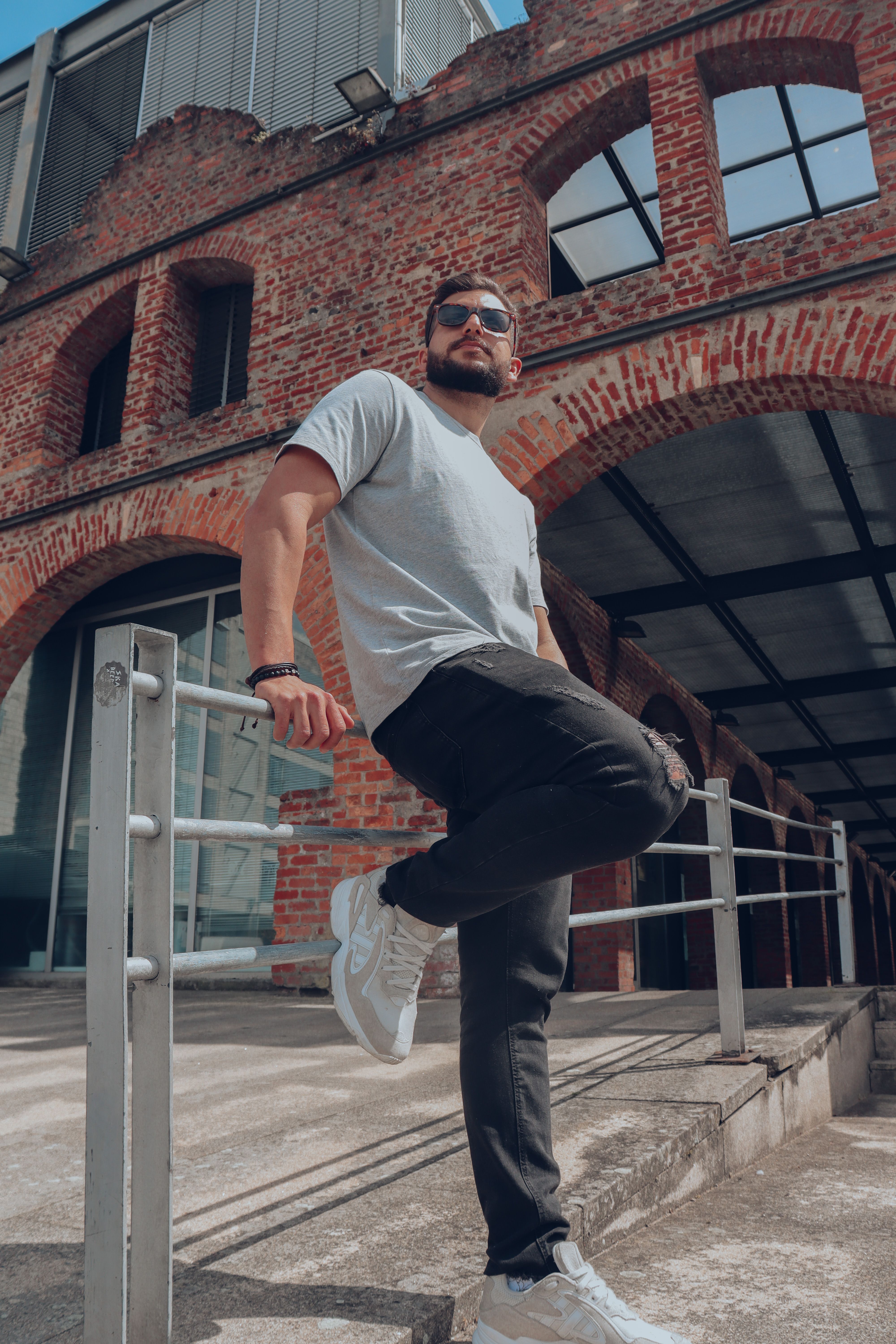 A Man Standing and Leaning on Metal Railing · Free Stock Photo