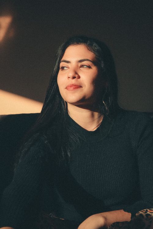 Free Warm, candid portrait of a woman in a knitted sweater, basking in natural light. Stock Photo