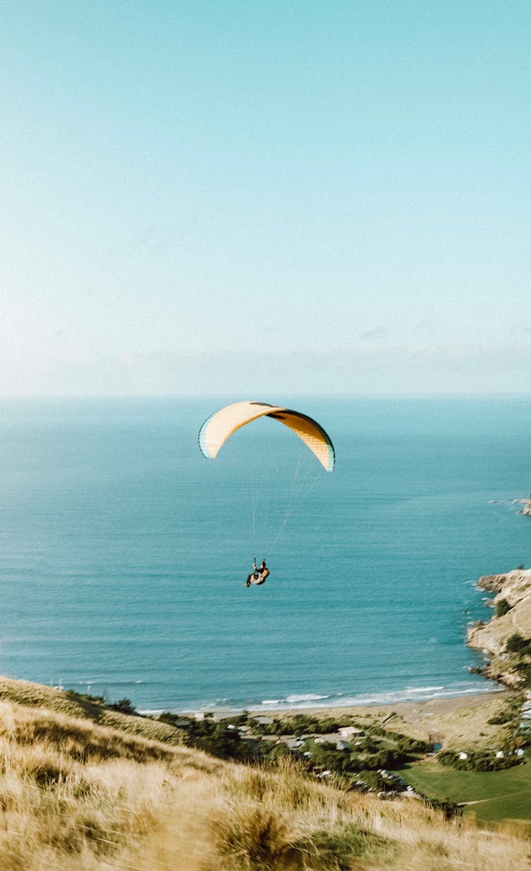 A Person Paragliding Over Blue Sea