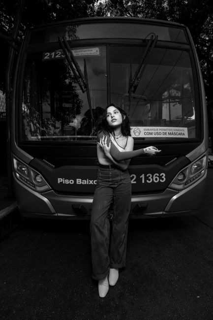 Monochrome image of a woman posing in front of a bus in São Paulo, Brazil.
